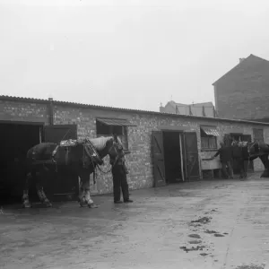A man walks a horse out of the stables. 1936 A man walks a horse out of the stables. 1936
