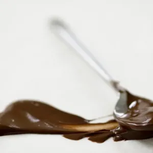 Melted chocolate on teaspoon, with smear of chocolate on greaseproof paper credit Melted chocolate on teaspoon, with smear of chocolate on greaseproof paper credit