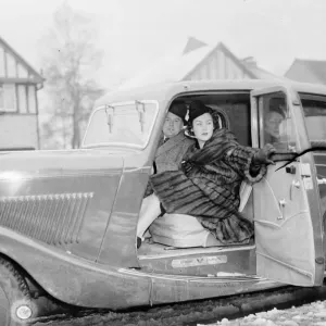 Miss Muriel Oxford sitting in the passenger seat of a car at the side of the road. 1937 Miss Muriel Oxford sitting in the passenger seat of a car at the side of the road. 1937