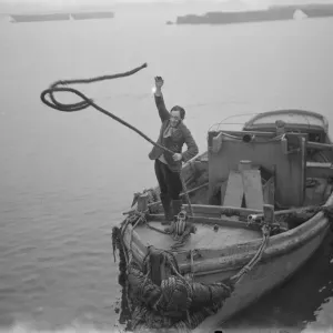 Print of Mr Frank Clark MP tying up a boat at the quay side in 1936