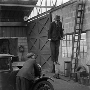 Mr Herbert Gilbertson on a trapeze in his garage in Sidcup. 1935