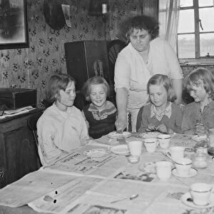 Mrs W E Wakefield with her daughters sitting by the dining table at their home in