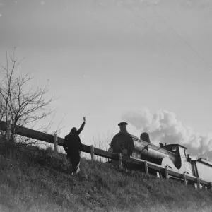 Muriel Haken waves to a passing train from a railway embankment, 1939 Print