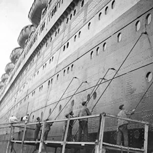 Painters dwarfed by the bulk of the Queen Elizabeth, the worlds largest liner