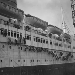 Painters dwarfed by the huge bulk of the Queen Elizabeth, the worlds largest liner Painters dwarfed by the huge bulk of the Queen Elizabeth, the worlds largest liner
