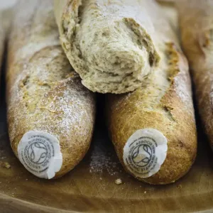 Pile of stoneground wholemeal organic baguettes on woden board credit: Marie-Louise