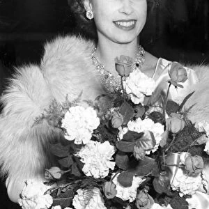 Princess Elizabeth wearing a tiara and carrying a bouquet of flowers at Warner Theatre