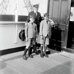 Black and white photograph print of two young boys with a ship's captain Black and white photograph print of two young boys with a ship's captain