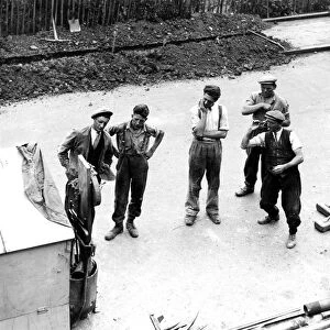 The road workers take a break from their manual labour for a cigarette and a game