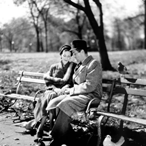 Romantic cliched couple. 1950 s. Couple having a quiet moment in the park