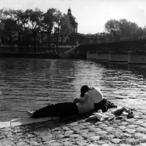 Print of a couple strolling along the Seine River in Paris Print of a couple strolling along the Seine River in Paris