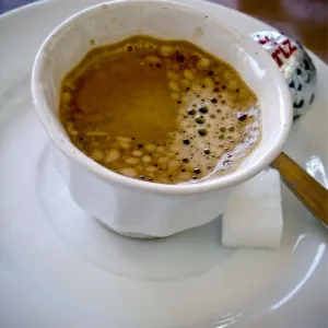 Small handleless cup of strong Turkish coffee on cafe table credit: Marie-Louise