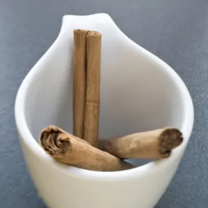 Sticks of cinnamon in small white cup credit: Marie-Louise Avery / thePictureKitchen