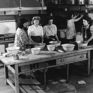 Teaching young women cooking in a kitchen 1950s Teaching young women cooking in a kitchen 1950s