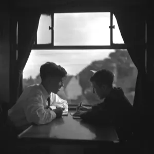 Trainspotters Club outing Two young trainspotters plan their day in the railway carriage Trainspotters Club outing Two young trainspotters plan their day in the railway carriage
