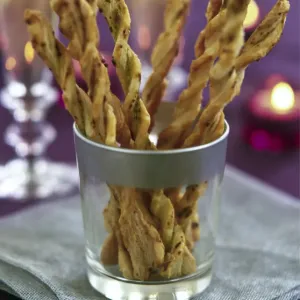 Twisted cheese straws in silver rimmed glass in candlelit party setting credit Twisted cheese straws in silver rimmed glass in candlelit party setting credit