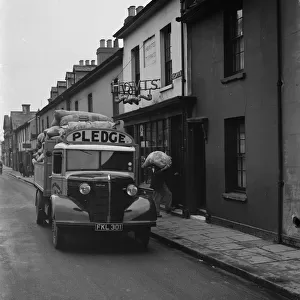 Workers are unloading sacks of flour from a Bedford truck belonging to Pledge & Son Ltd