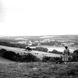 A young woman admires a view across the Weald of Kent