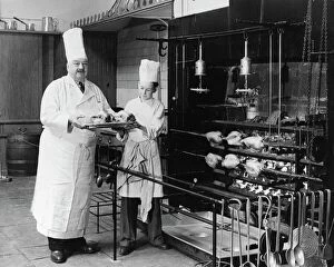 1950s Collection: A. H. Cadier, senior chef at the Brighton Pavilion is handed fake chickens by junior