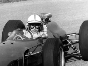 After his accident world famous auto racer John Surtees has stepped into a racing