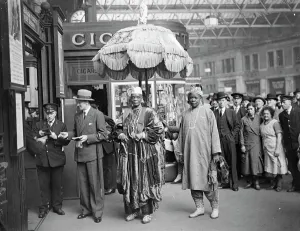 African ruler leaves thoughtfully to review under Royal umbrella. The Alake of Abeokuta