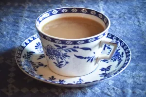 Antique blue and white cup and saucer of Indian tea with milk, on blue tablecloth