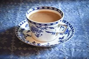 Food Collection: Antique blue and white cup and saucer of Indian tea with milk, on blue tablecloth