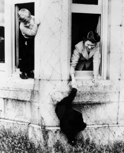 Balmoral: Prince Charles peeping round the corner as he stands on the window sill sees his sister
