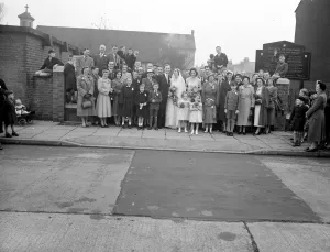 Marriage Prints: Banks / Sumner wedding. The bride and groom with all their guests outside the church. 1954