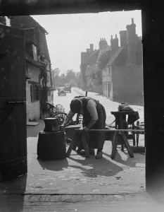 Doorway Prints: The Blacksmith at work at Westerham Forge, Kent. 1935