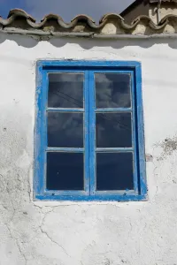 Blue Prints: Blue framed window in white wall of Greek Cypriot house credit: Marie-Louise Avery
