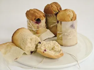 Blueberry muffins made in talll paper cases of greaseproof paper tied with string credit