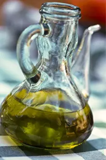 Bottle Prints: Bottle of olive oil on outdoor restaurant table in southern France, with reflection