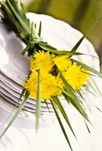 Decorative Prints: Bouquet of dandelions and long blades of grass on stack of white plates as table