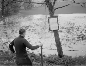 Fence Prints: A boy looks at the flooded Sidcup swimming pool - flooded due to the bad weather