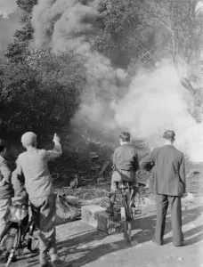 Smoke Prints: Boys with their bicycles watch the smoke rising in clumps following fresh breakout