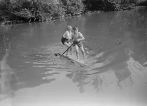 Playing Prints: Boys crossing the river on a raft. 1935