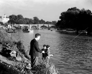 Fishing Prints: Boys fishing by the riverside on the Thames at Richmond, London, England, UK