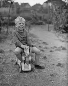 Playing Prints: Brian Griffiths riding a wooden horse. 1938