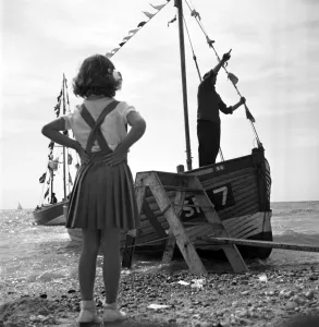 Beach Prints: Brighton Little girl staring out to see looking at a tourist boat in Brighton 1950