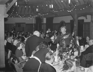 Glass Prints: Burns night in Bexleyheath, Kent. The bagpiper is give a drink. 4 February 1939