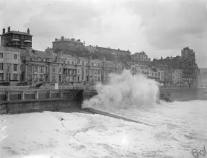 Bursting in fury against the sea wall, huge waves lashed to a white fury by the gale