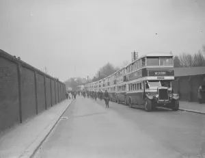 Wall Prints: Buses parked on the road outside Chatham dockyard. Dock workers cycling past