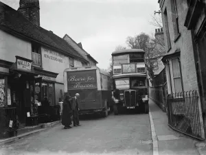 A butcher van and the number 21 bus squeeze past each other in the tight Farningham