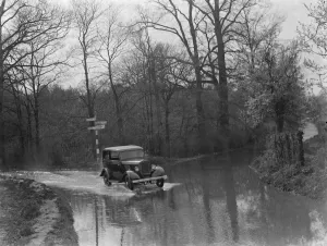 Wood Prints: A car drives through the floods in Hockenden, Kent. 1937