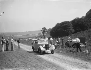 Spectators Prints: A car struggle over the summit in the up hill rally. 1936
