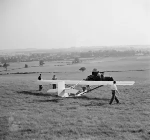 A Cessna CG-2 Glider is being hitched up to its tow line, in preperation for its