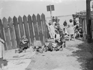 Children have come to the riverside on the Thames estuary at Gravesend, Kent, to