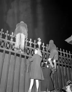 Wedding Prints: Children among the crowds outside the Palace tonight climbed the railings to get