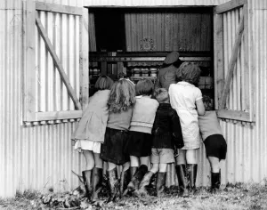 Children on a hop pickers holiday in Kent. They are watching a machine that may replace